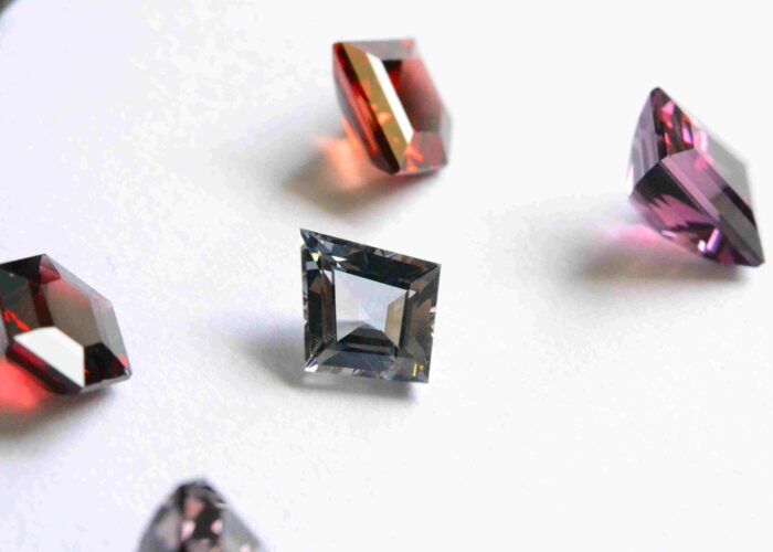 A fancy cut (kite) Burmese grey spinel, amongst a Burmese spinel lot.
